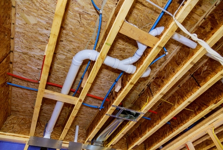 Exposed piping in an attic.